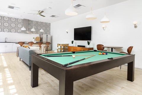a living room with a pool table and a tv